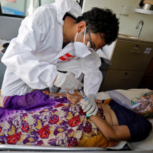 A doctor tends to a patient with a breathing problem inside an ambulance waiting to enter a COVID-19 hospital for treatment, amidst the spread of the coronavirus disease (COVID-19) in Ahmedabad, India, April 25, 2021. REUTERS/Amit Dave
